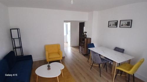 un salon avec une table et des chaises jaunes dans l'établissement ZenMeublerMontfavet, à Avignon