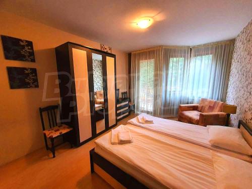 a bedroom with a bed and a chair and a mirror at Студио в Хотел Айсберг in Borovets