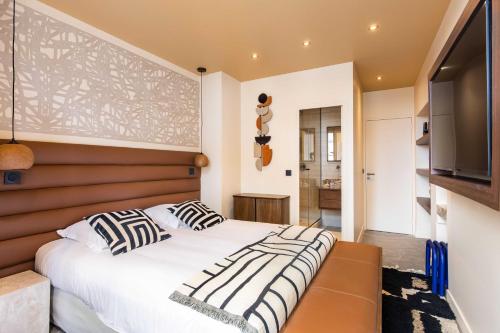 une chambre avec un grand lit et une télévision à écran plat dans l'établissement Gorgeous apartment - 2BR-8P - Le Marais, à Paris