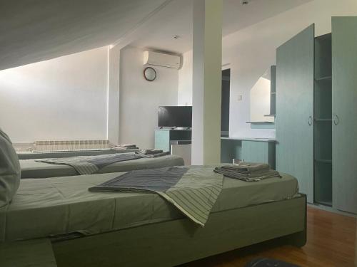 a room with three beds and a tv in it at Motel Maestro in Deva