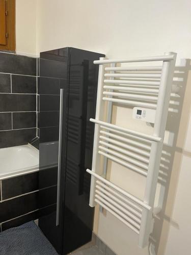 une étagère dans une cuisine avec un réfrigérateur noir dans l'établissement Jolie maison, à Gurgy