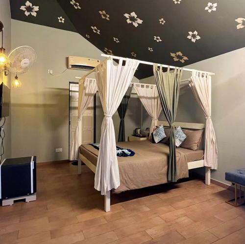 a bedroom with a bed with a canopy at The Village Resort in Kodāe