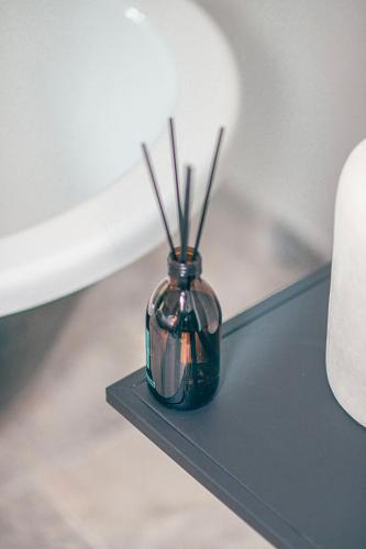 a glass vase with sticks in it sitting on a table at Les Suites de l'Étang in Cucuron