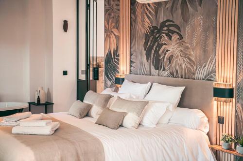 a bedroom with a large bed with white pillows at Les Suites de l'Étang in Cucuron