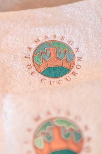a close up of a company logo on a towel at Les Suites de l'Étang in Cucuron