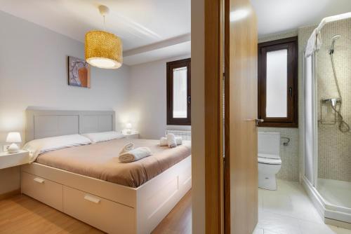 a bedroom with a large bed and a bathroom at Casa Constanza, familiar y en el centro de Panticosa in Panticosa