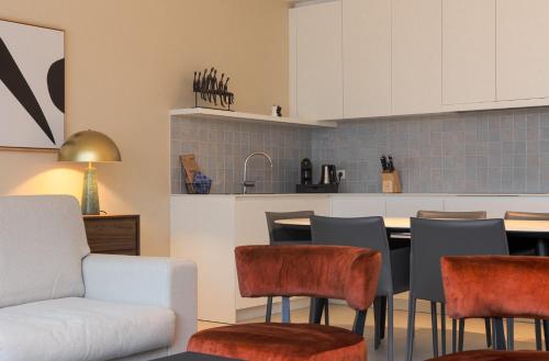 a kitchen with a couch and a table and chairs at Sky Bridge Ostend - Casselbergh Residences in Ostend