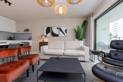 a living room with a couch and a table at Sky Bridge Ostend - Casselbergh Residences in Ostend