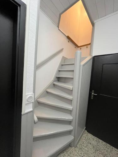 a stairway with white stairs in a room at Bienvenue chez Coco in Dunkerque