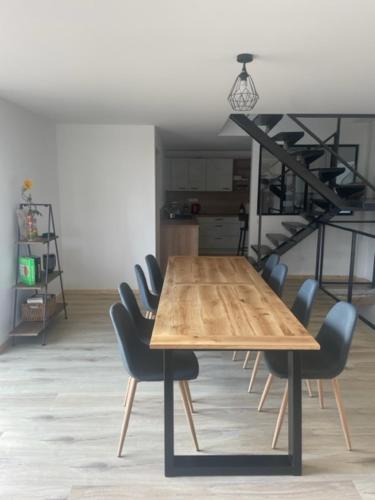 a dining room table with chairs and a staircase at Gite authentique au coeur de Blavozy avec piscine privée, jacuzzi et terrain de pétanque in Blavozy