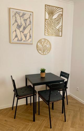 a black table with two chairs and a plant on it at Bahama apartments in Bucsuháza