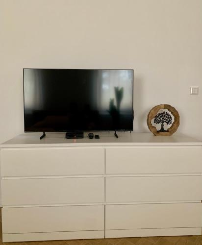 a flat screen tv sitting on top of a white dresser at Bahama apartments in Bucsuháza