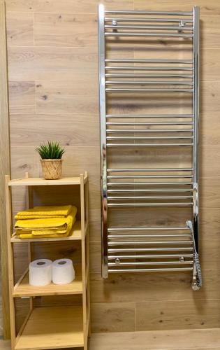 a metal towel rack on a wall next to two shelves at Bahama apartments in Bucsuháza