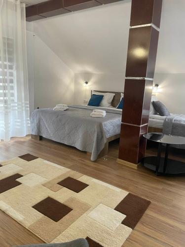 a bedroom with a bed and a table and a rug at Motel Maestro in Deva