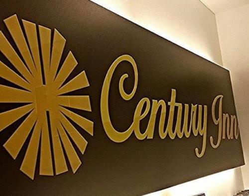 a sign for a store with a gold star on the wall at Century Inn Hotel in Cukai