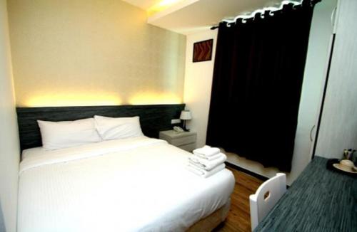 a bedroom with a white bed and a window at Century Inn Hotel in Cukai