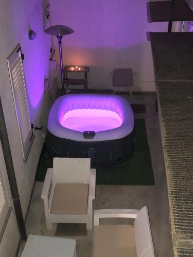 a purple room with a tub and a table and chairs at LOFT CON CORTILE in Forlì