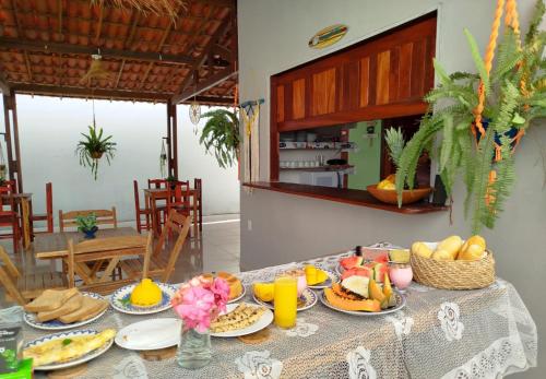 a table topped with plates of food and orange juice at Villa dos Coqueirais in Icaraí