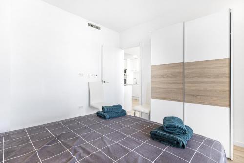 Una habitación con dos toallas azules sobre un suelo de baldosas. en Belle, en Playas de Orihuela