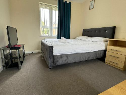 a bedroom with a bed and a desk with a television at Central Birmingham in Birmingham