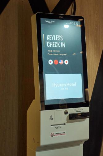 a keyless check in machine with a screen on it at Hyuzen Hotel - 휴젠 in Seoul