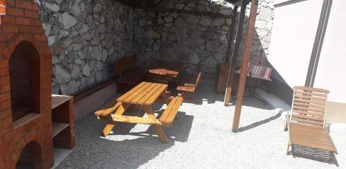 a picnic table and benches in front of a stone building at Casa Laura in Orşova