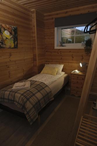 a small bedroom with a bed and a window at 3ART recreation in Tromsø