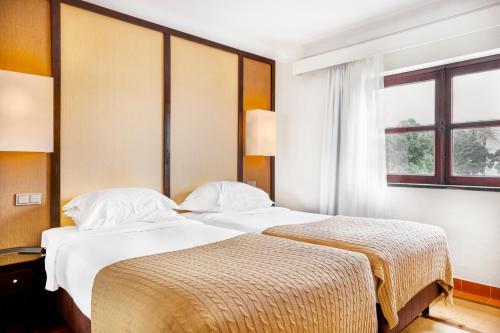 a hotel room with two beds and a window at Pousada Forte da Horta in Horta