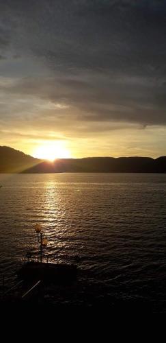 a sunset over a large body of water with a boat at Casa Laura in Orşova