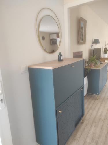 une armoire bleue dans une pièce avec un miroir dans l'établissement F1 Chez Ademax, à Saint Lo