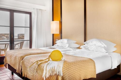 a hotel room with a bed with a yellow bag on it at Pousada Forte da Horta in Horta