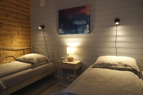 a bedroom with two beds and a table with a lamp at 3ART recreation in Tromsø