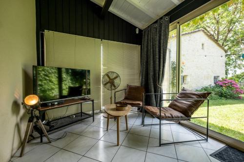 a living room with two chairs and a television at L'Annexe Mauvilla in Civrac-de-Dordogne