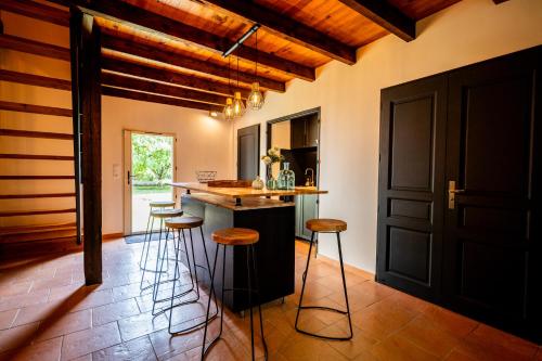 a kitchen with a counter and stools in a room at L'Annexe Mauvilla in Civrac-de-Dordogne