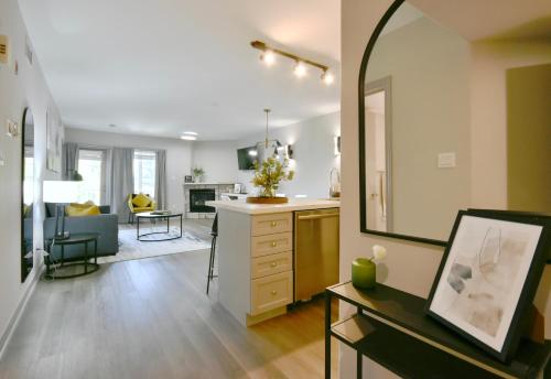 a kitchen and living room with a large mirror at Horseshoe Valley Bliss - Luxe Condo Retreat with Jacuzzi - Top Floor Romance - Self-Check-in - Indoor & Outdoor Heated Pool Haven in Shanty Bay