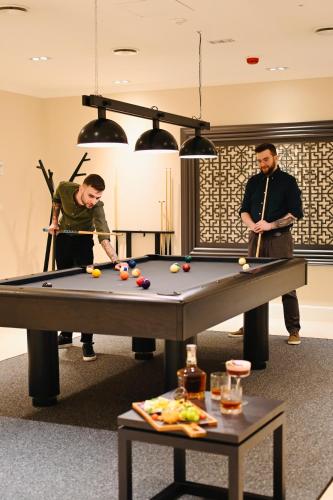 two men playing a game of pool in a room at Hotel Sokół Wellness & SPA in Łańcut