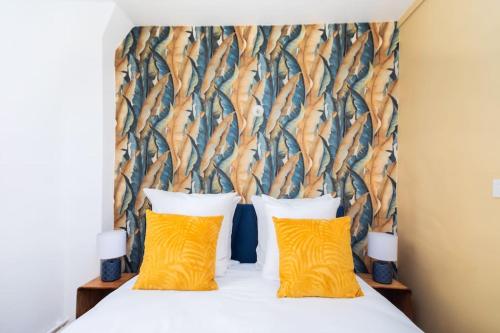 - une chambre avec un lit et 2 oreillers jaunes dans l'établissement Appartement Plein Pied cœur de Neuilly-sur-seine, à Neuilly-sur-Seine