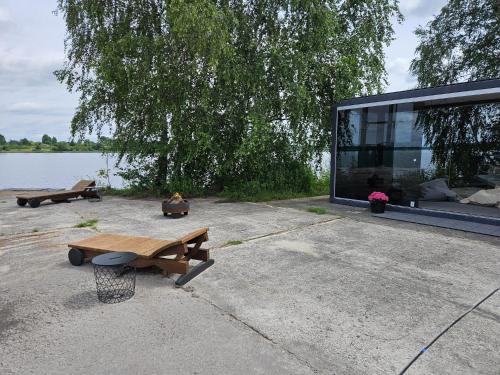 a building with a picnic table next to a lake at Pamesta kuģu piestātne in Katlakalns