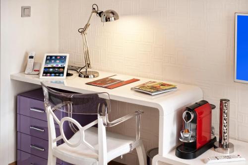 a white desk with a chair and a lamp at Nuru Ziya Residences in Istanbul