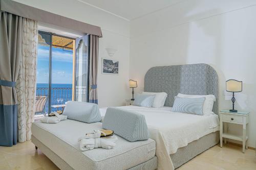 a bedroom with a large bed and a balcony at Albergo Miramare Positano in Positano