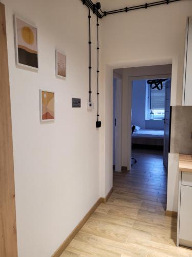 un pasillo con una pared blanca con pinturas. en Axo-Hostel 10, en Stalowa Wola
