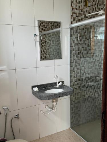 a bathroom with a sink and a shower at Hotel Ondas do Mar in Salinópolis