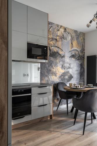 a kitchen with a table and a wall mural at RentPlanet - Kępa Mieszczańska in Wrocław