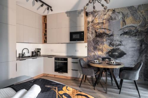 a kitchen with a table and chairs in a room at RentPlanet - Kępa Mieszczańska in Wrocław