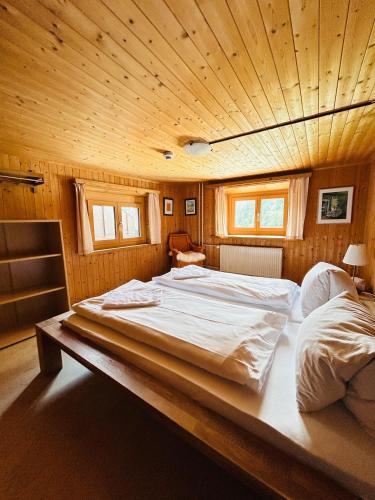 a large bed in a room with a wooden ceiling at Gasthaus Rössli in Versam