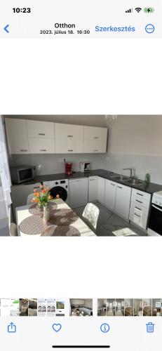 a picture of a kitchen with a table with a plant at Aranyapartman in Kisbajcs