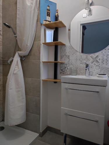 une salle de bain avec un lavabo et un miroir dans l'établissement Maison et jardin entre Paris et Disney. Idéal JO, à Rosny-sous-Bois