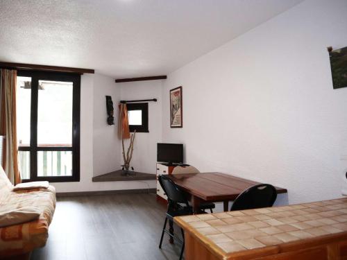 - un salon avec une table en bois et un bureau dans l'établissement Studio pour 4 pers, au pied des pistes, vue sud, animaux admis - FR-1-322-55, aux Orres