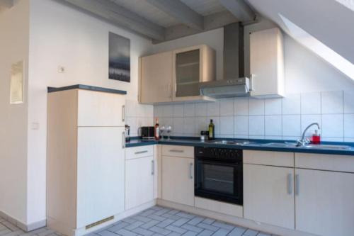 a kitchen with white cabinets and blue counter tops at Alt Mölln, Wohnung 12 in Alt Mölln
