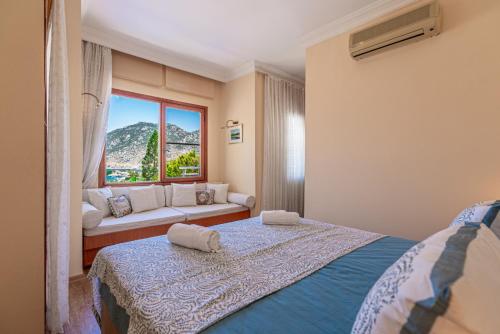 a bedroom with a bed and a window with a couch at Selimiye Meltem's in Marmaris